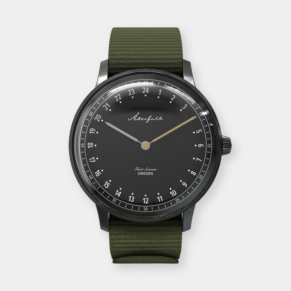 24-hour watch with matte black case and green NATO strap