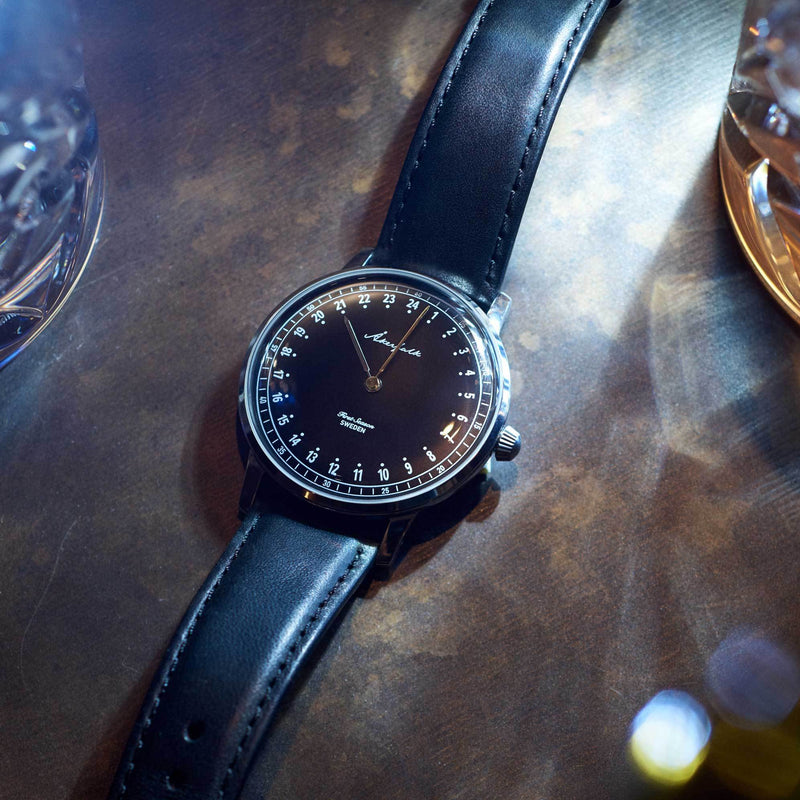 24-hour watch with silver case and black leather strap